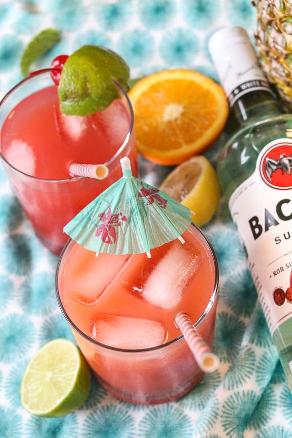 bottle of bacardi light rum next to rum punch drinks