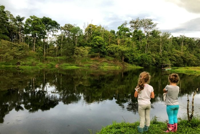 Children standing by crystalline lake.