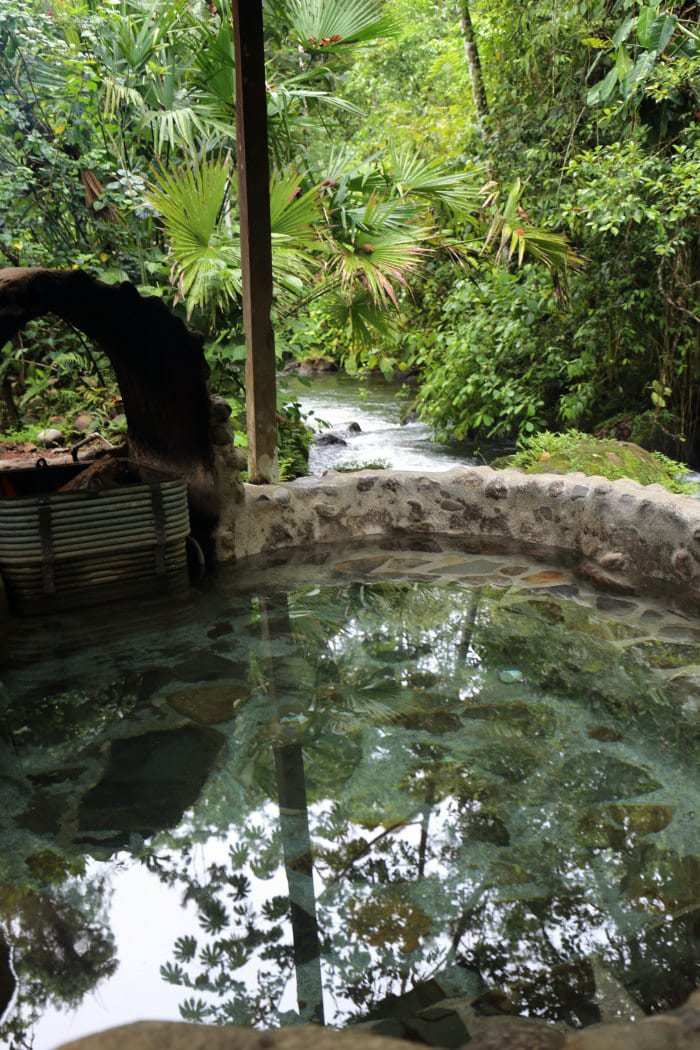 Green water hot tub by river.