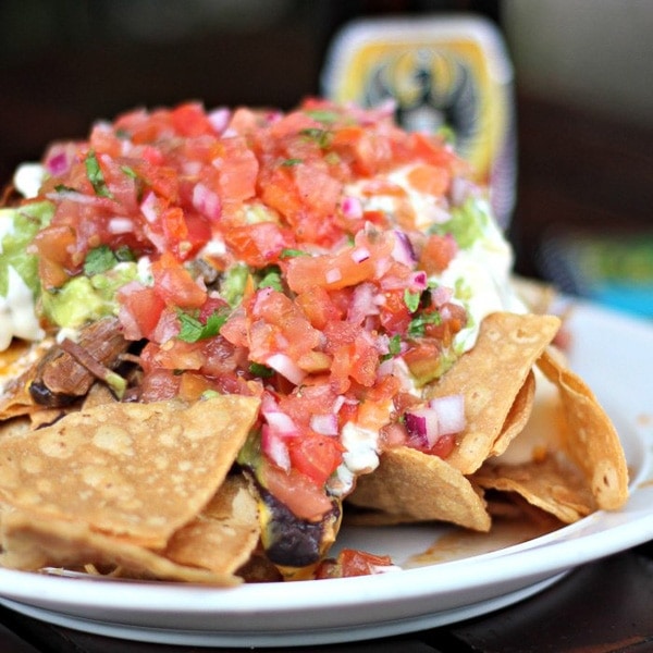 Plate of Costa Rican nachos piled with pico de gallo.