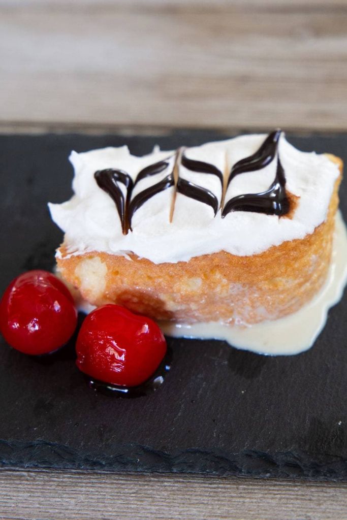 slice of tres leches cake on a black slate board