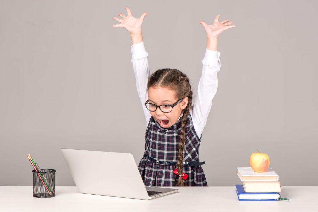 little girl with glasses with her hands up