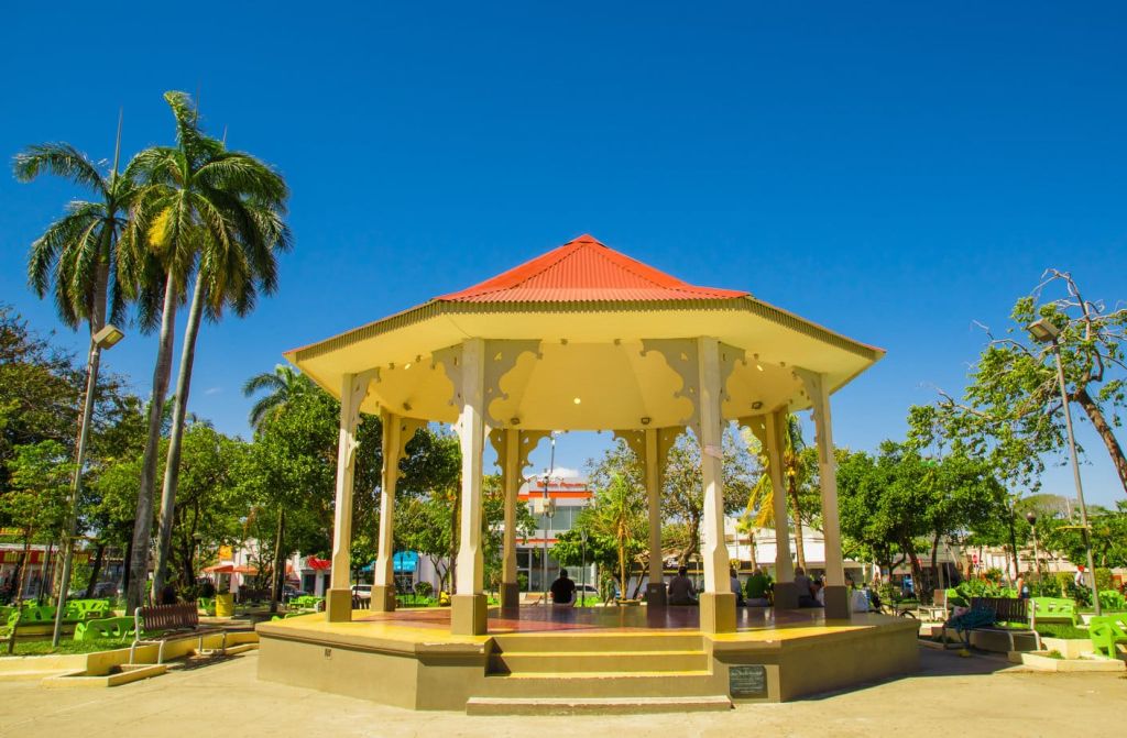 Outdoor view of people resting inside of a building in the middle of the park in Liberia Guanacaste Costa Rica in gorgeous blue sky in summer day.