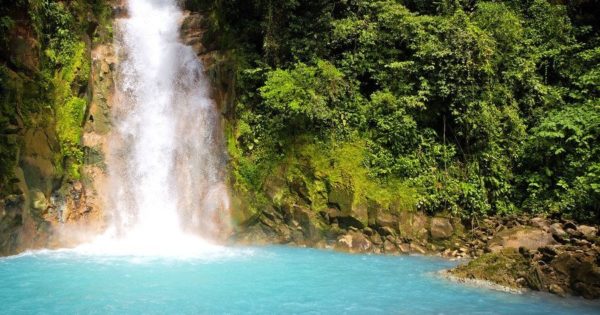 Waterfall cascading into an aquamarine pool.